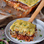 gluten-free vegan moussaka on a plate with a wooden spatula