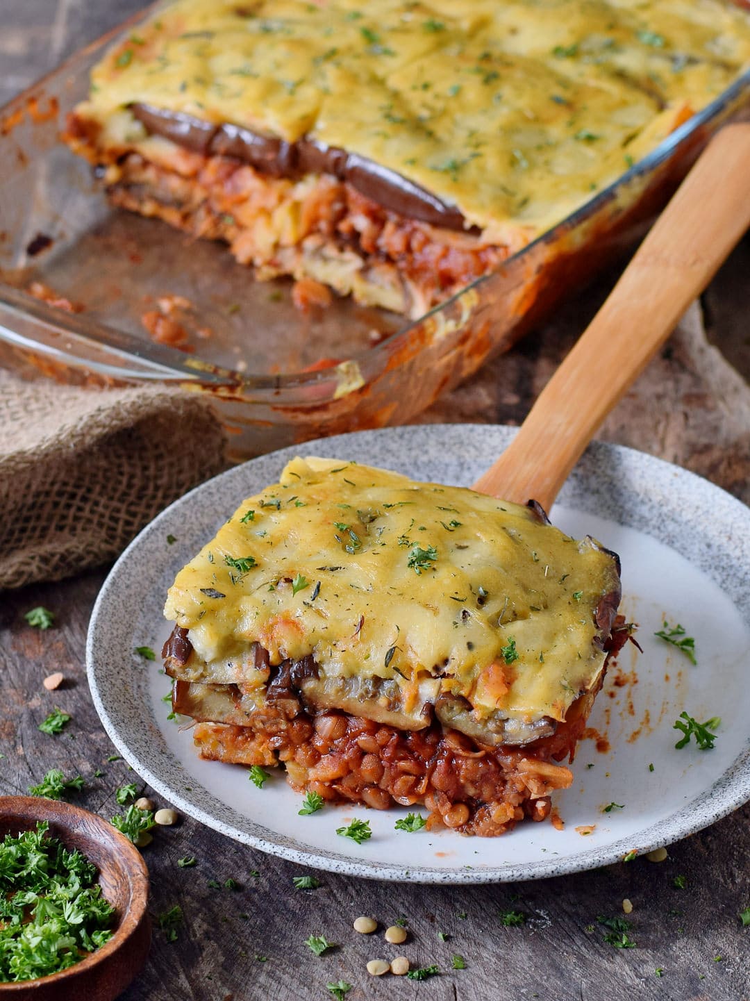 vegan moussaka on a plate with a wooden spatula