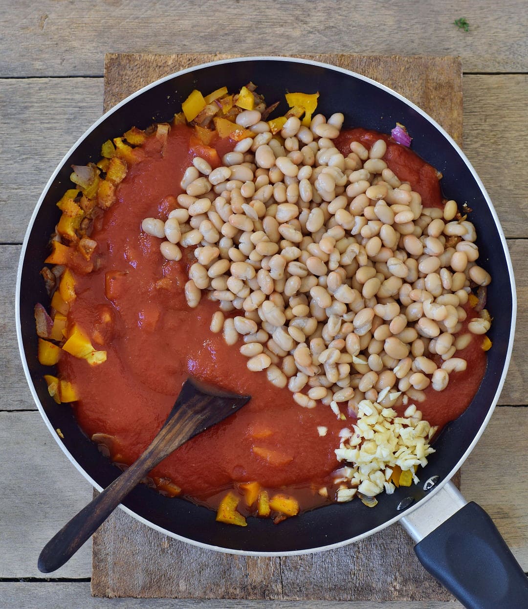 tomato sauce with cannellini beans and veggies in a pan
