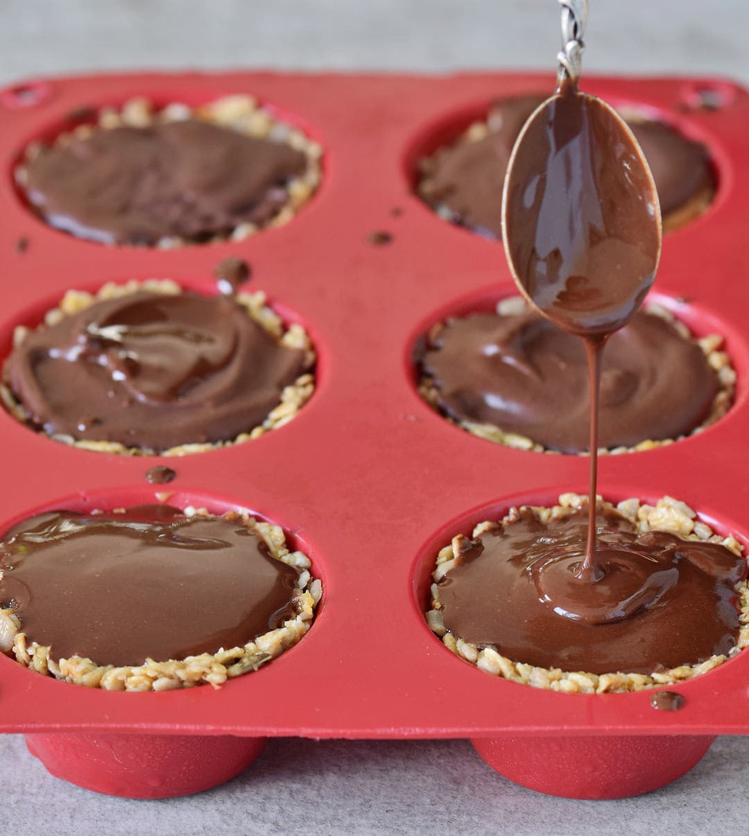 vegan breakfast granola cups with chocolate sauce in a red silicone mold