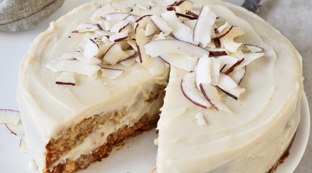 Gluten-free vegan coconut cream cake on white plate
