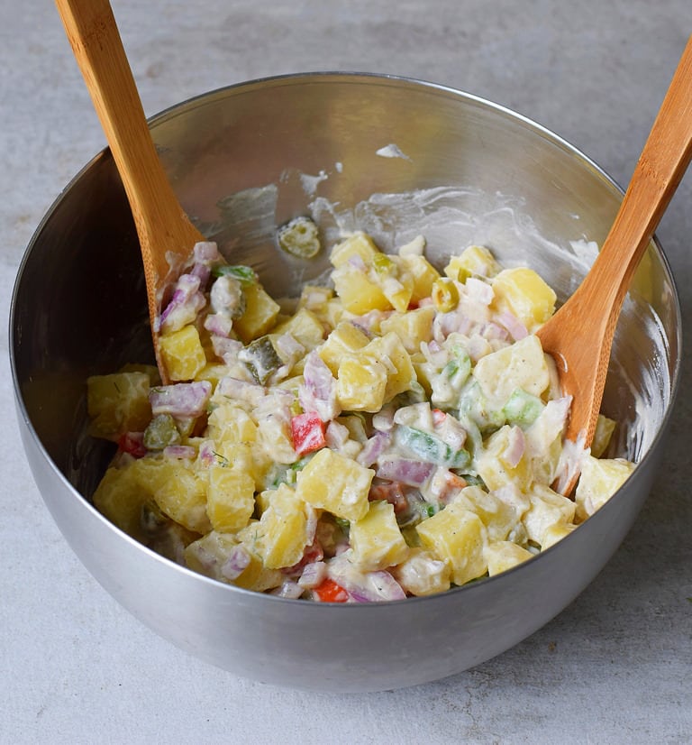 Veganer Kartoffelsalat mit Gemüse ohne Mayonnaise in einer silbernen Schüssel