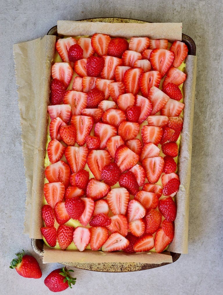 veganer Puddingkuchen mit Erdbeeren in einer Blechform 