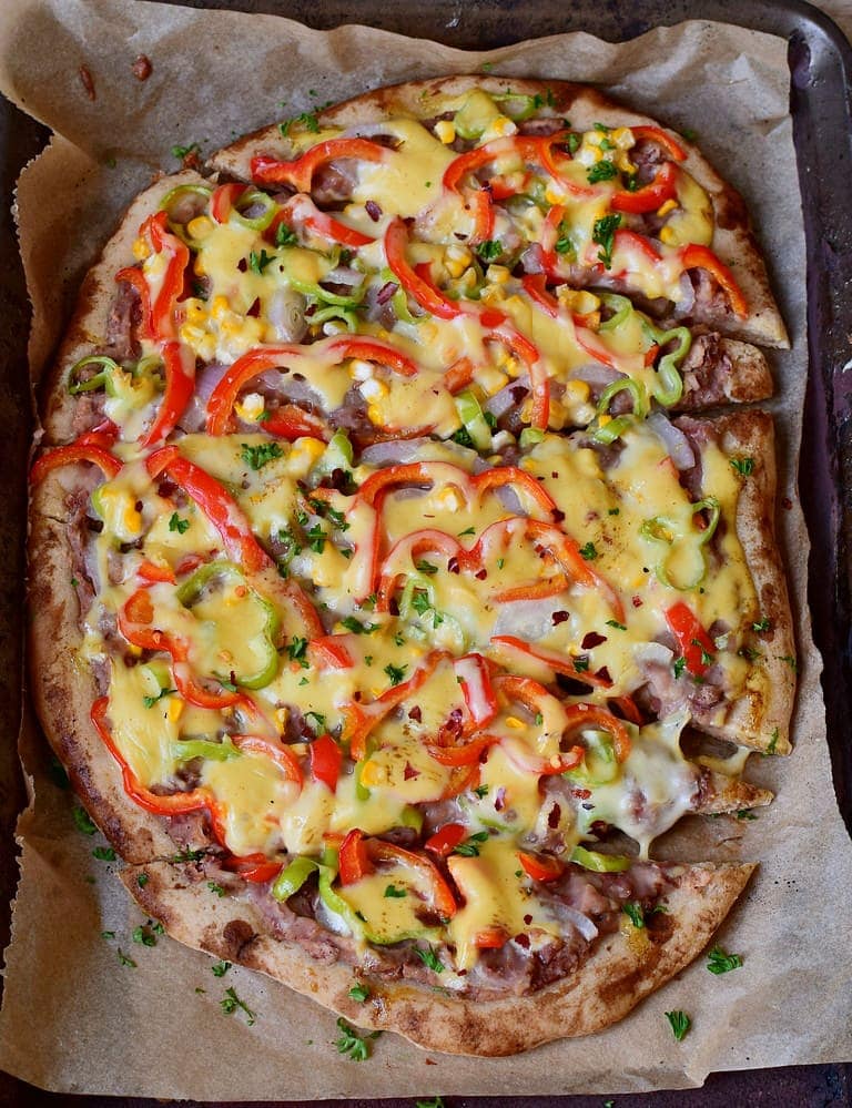 Loaded pizza with corn peppers jalapeno refried beans and vegan cheese