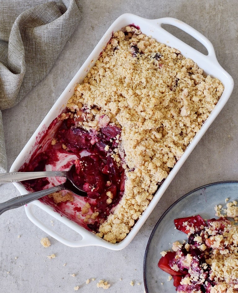 apple crisp with plums in a baking dish