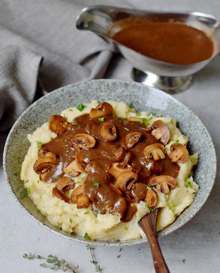 Bowl with mashed potatoes, vegan gravy, and mushrooms