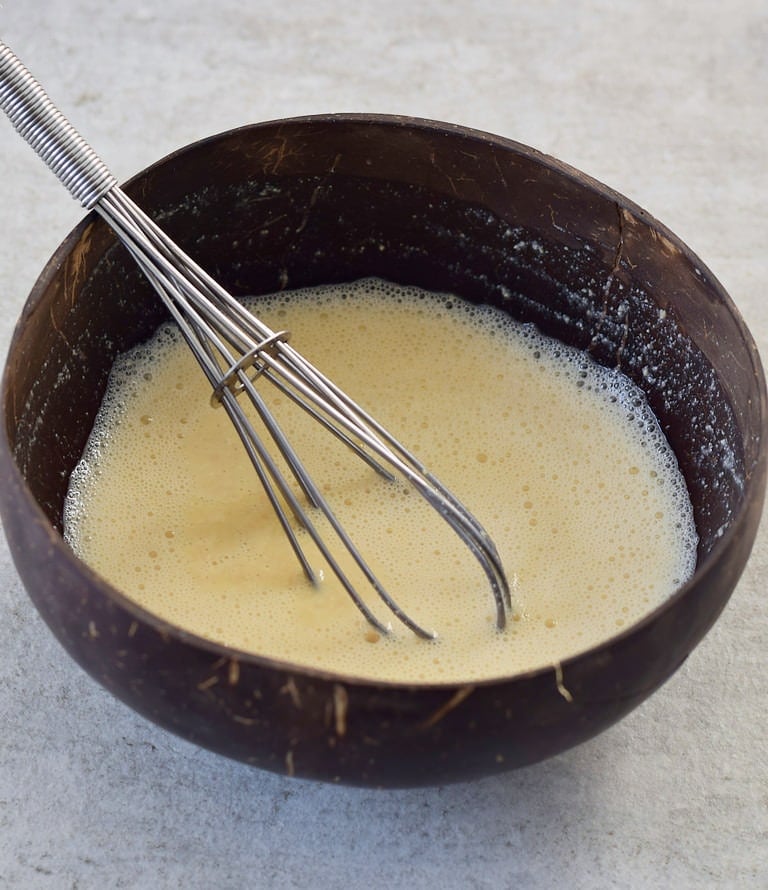 Kichererbsenmehl mit Speisestärke und Wasser vermischt in einer braunen Schale