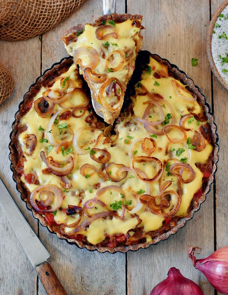 caramelized onion tart with a piece cut out