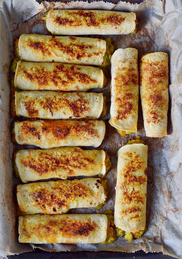 11 vegetable flautas on a baking sheet from above