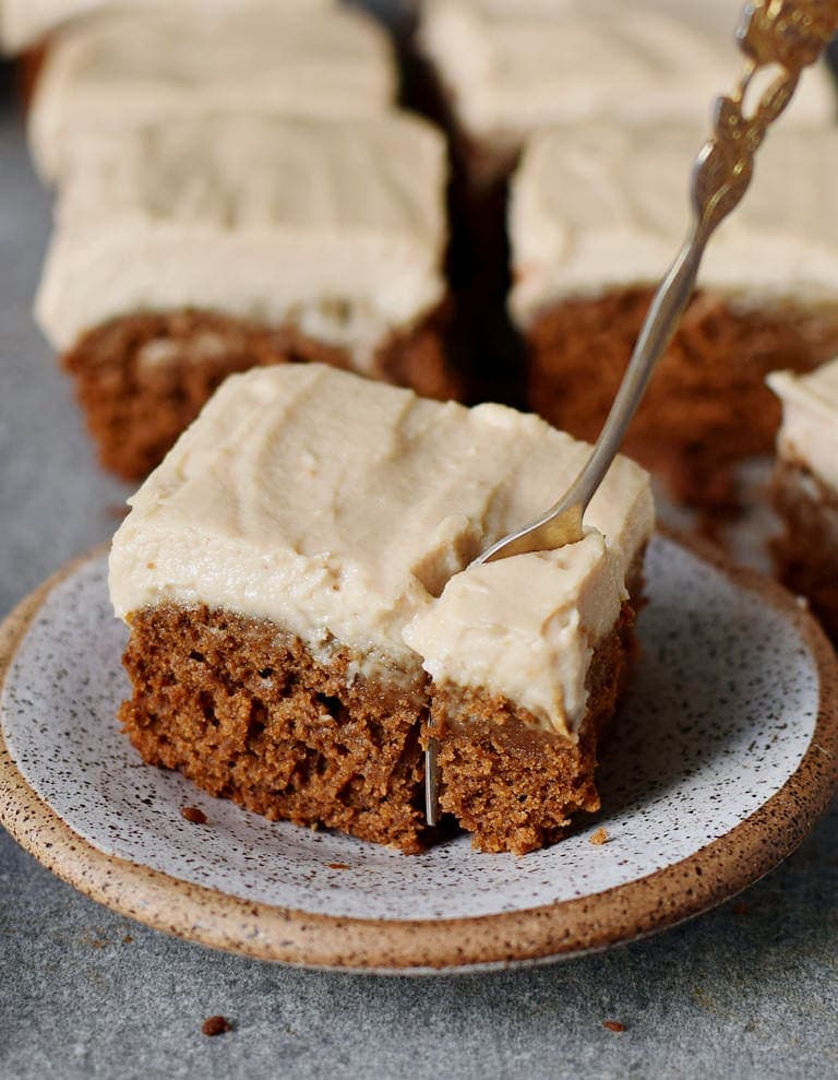 fork in a piece of vegan gingerbread cake with frosting