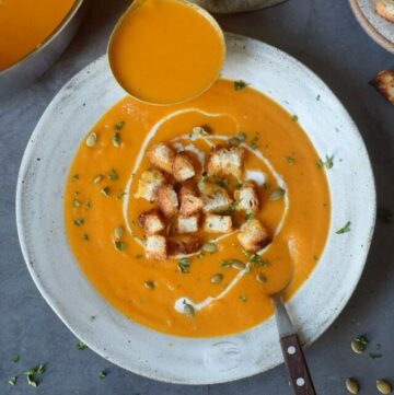 cropped-Gray-plate-with-carrot-soup-a-spoon-and-a-laddle.jpg