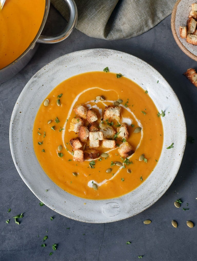orange soup with carrots pumpkin seeds and croutons
