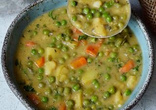 vegetable soup in bowl with ladle