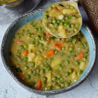vegetable soup in bowl with ladle