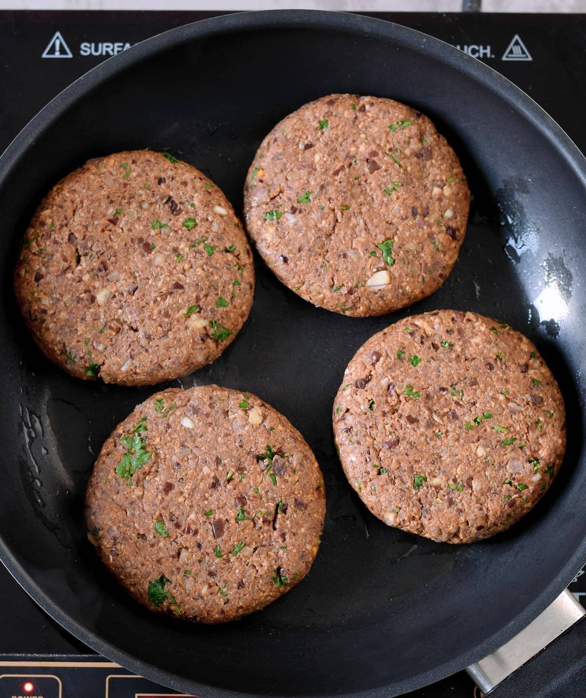 4 vegan black bean burgers in a pan
