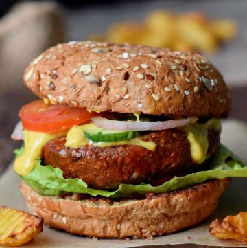 close-up of vegan black bean burger with veggies and cheese