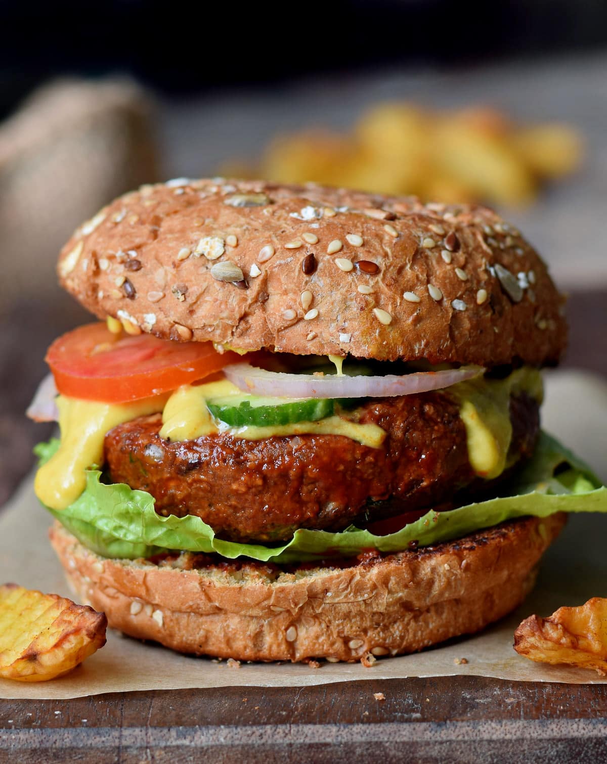 Nahaufnahme eines veganen Burgers aus schwarzen Bohnen mit Gemüse und Käse