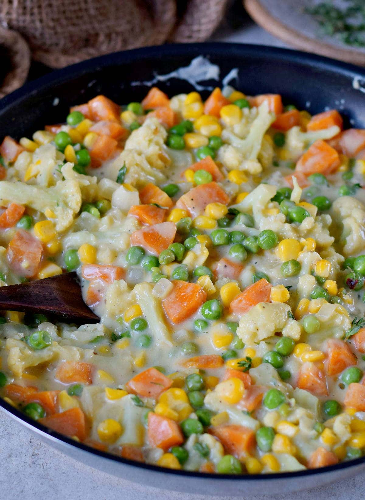 Close-up of creamed peas and carrots in a pan
