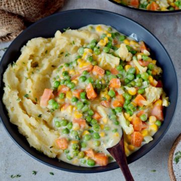 Vegan creamed peas and carrots over mashed potatoes
