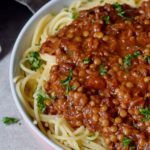 close-up of vegan lentil bolognese sauce over spaghetti