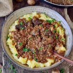 lentil stew over mashed potatoes in bowl