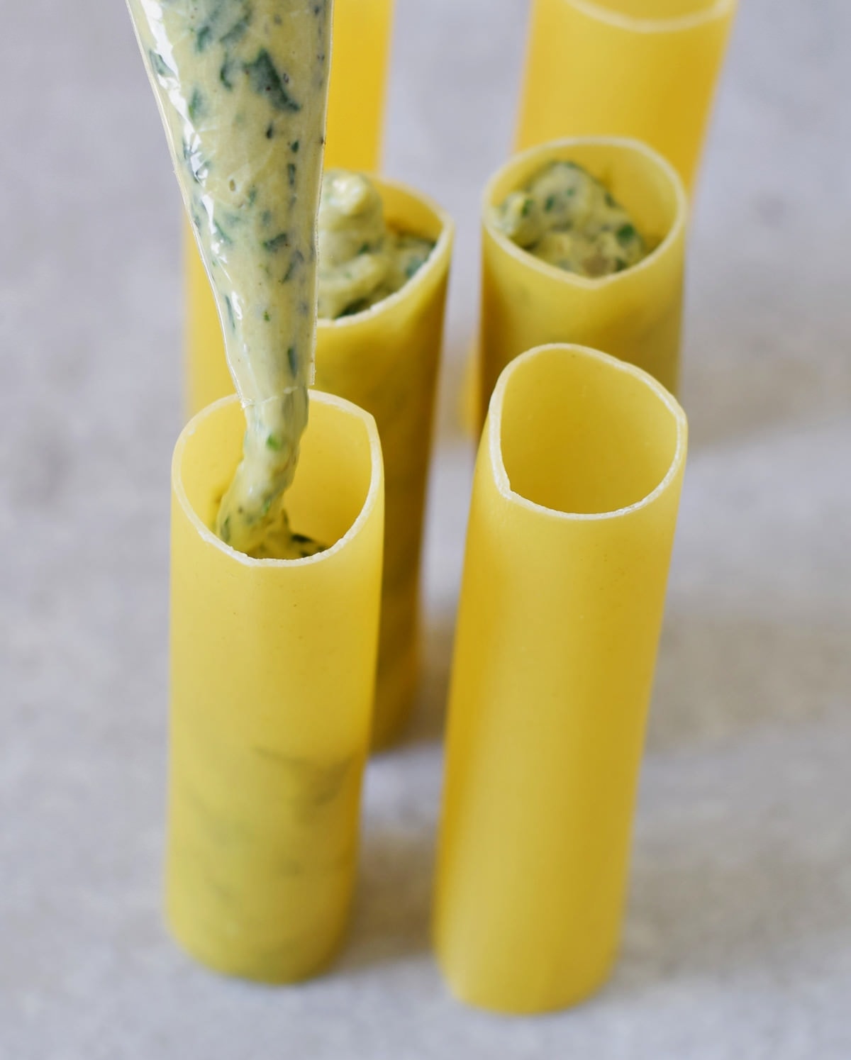 filling cannelloni tubes with ricotta and spinach mixture