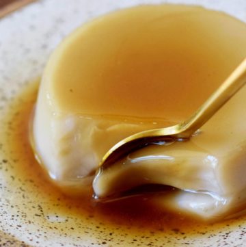 golden spoon submerged in vegan flan