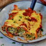 three spinach and ricotta stuffed cannelloni with vegan cheese