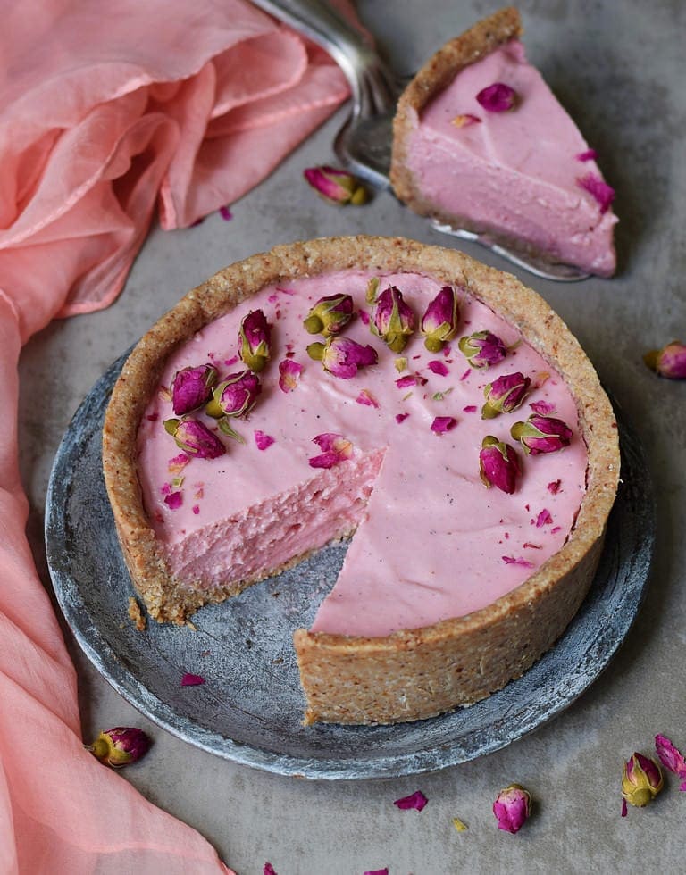 pink vegan no-bake cheesecake decorated with rose buds