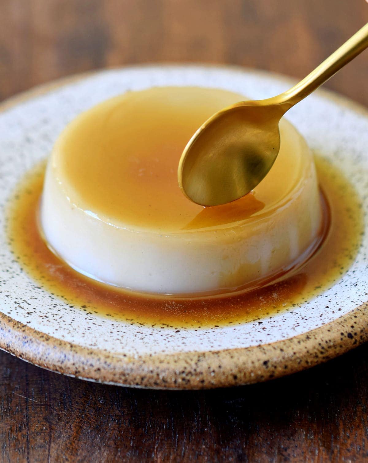 vegan flan on a plate with spoon hitting