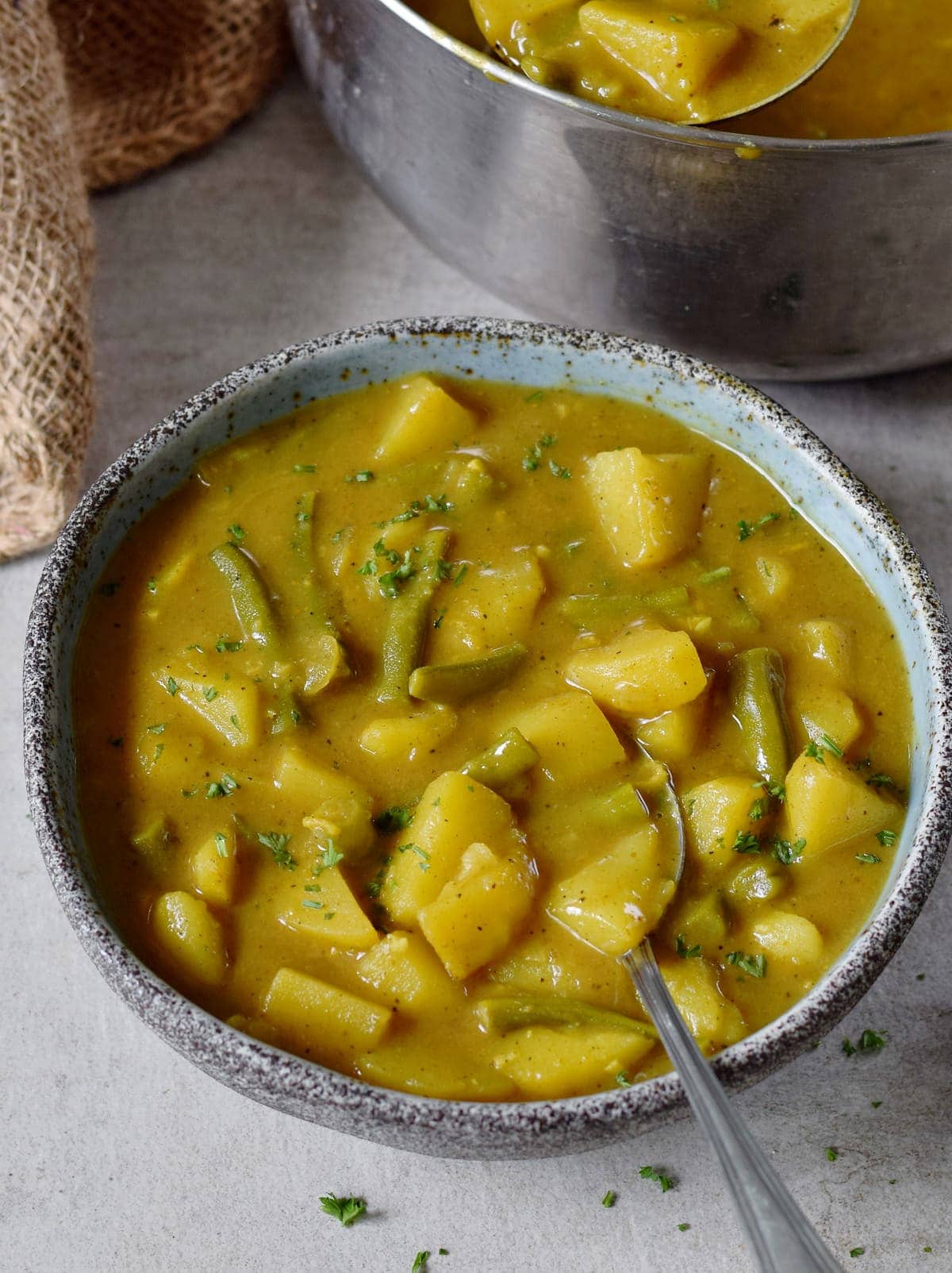 Veganes Kartoffel Curry mit grünen Bohnen in einer Schale