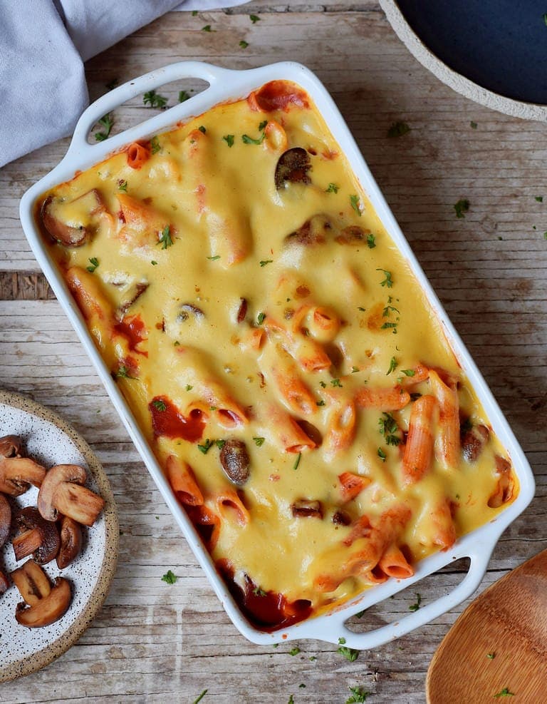 Vegan baked ziti with mushrooms and plant-based cheese in a casserole dish