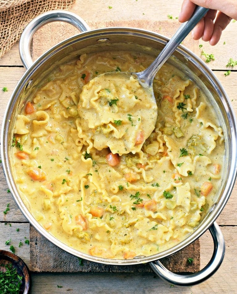 Vegan creamy pasta soup in a large pot with ladle