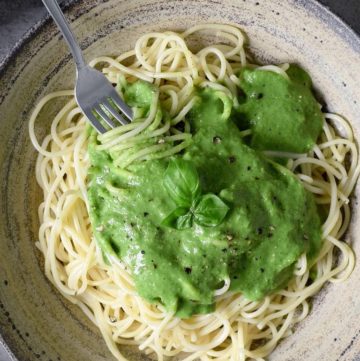Vegan spinach pasta sauce with spaghetti in a ceramic bowl