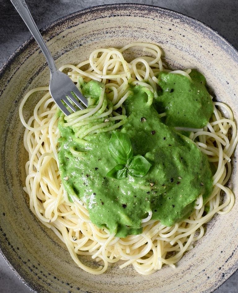 Vegan spinach pasta sauce with spaghetti in a ceramic bowl