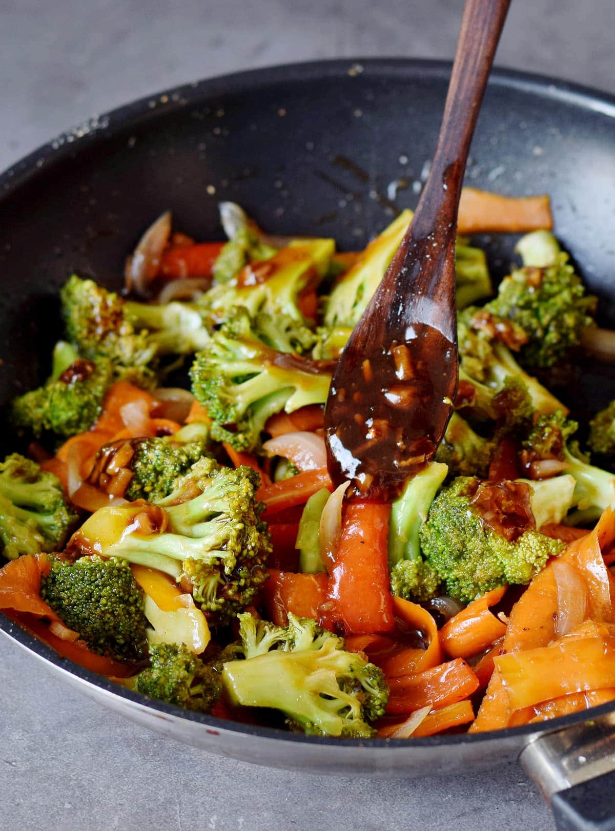 broccoli stir-fry with peppers and carrot slices in a skillet