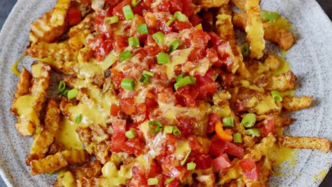 hand grabbing loaded chips on a large platter