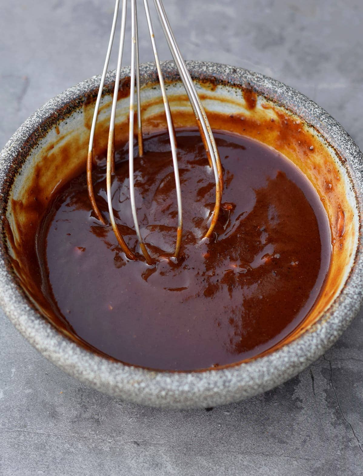 stirring hoisin sauce with a whisk in a bowl