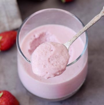 strawberry mousse in a glass with spoon showing the texture
