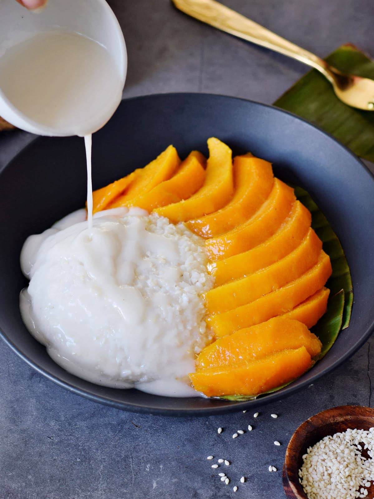 drizzling coconut sauce over mango sticky rice
