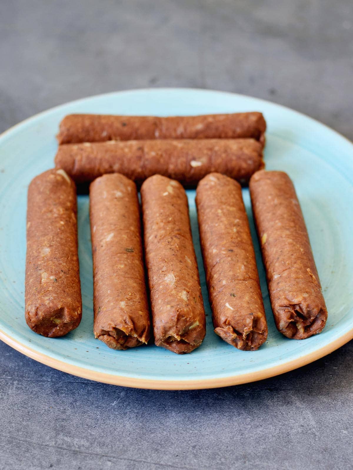 7 steamed vegan sausages on a plate