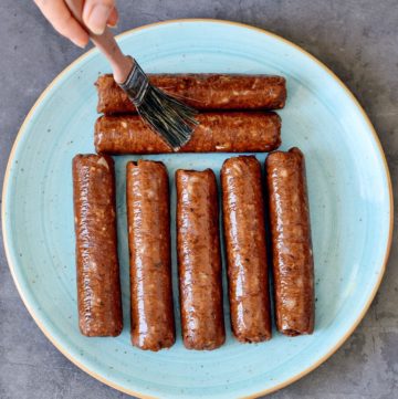 vegan sausages on plate brushed with oil