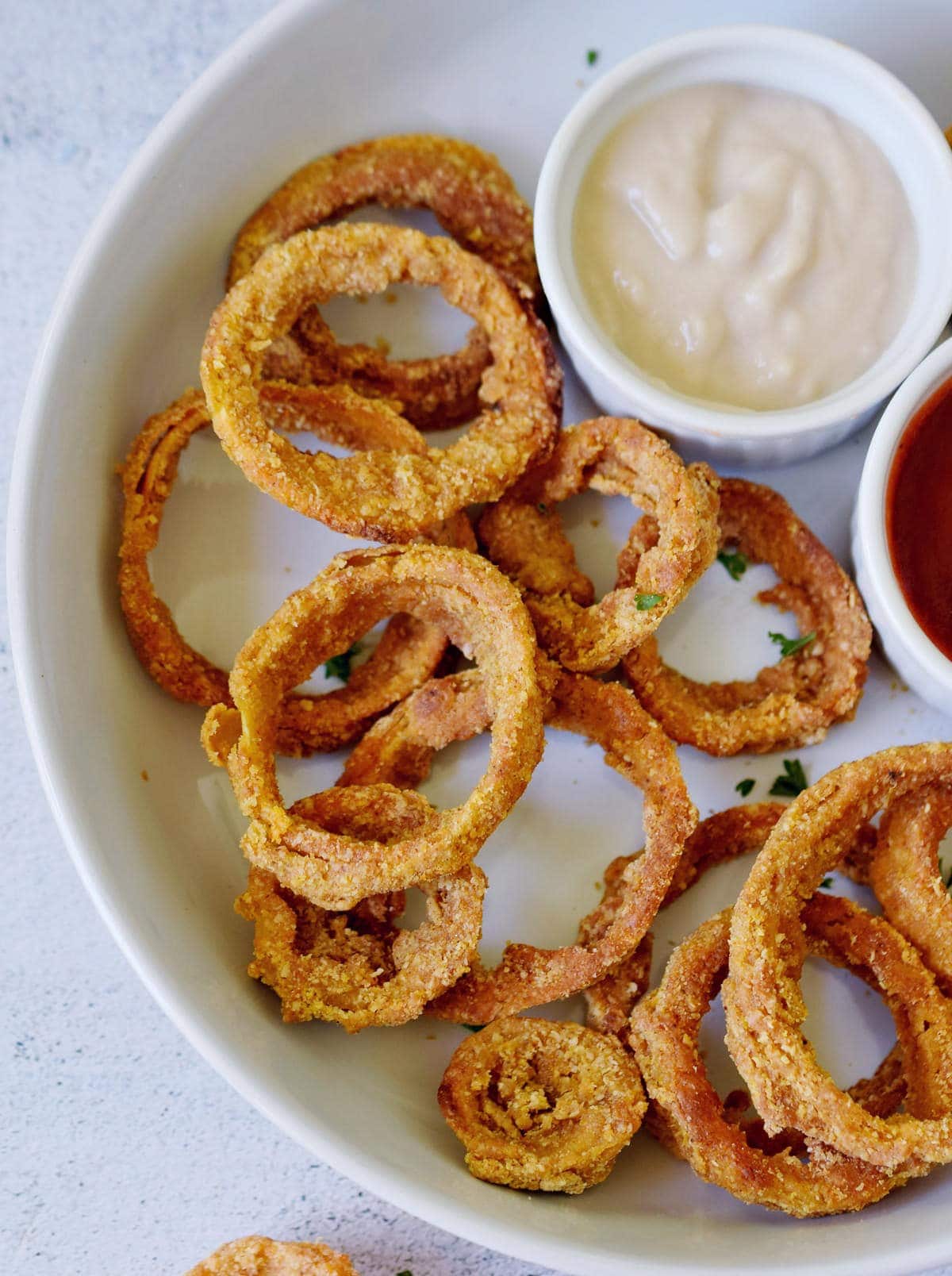 close-up of vegan onion rings with dips