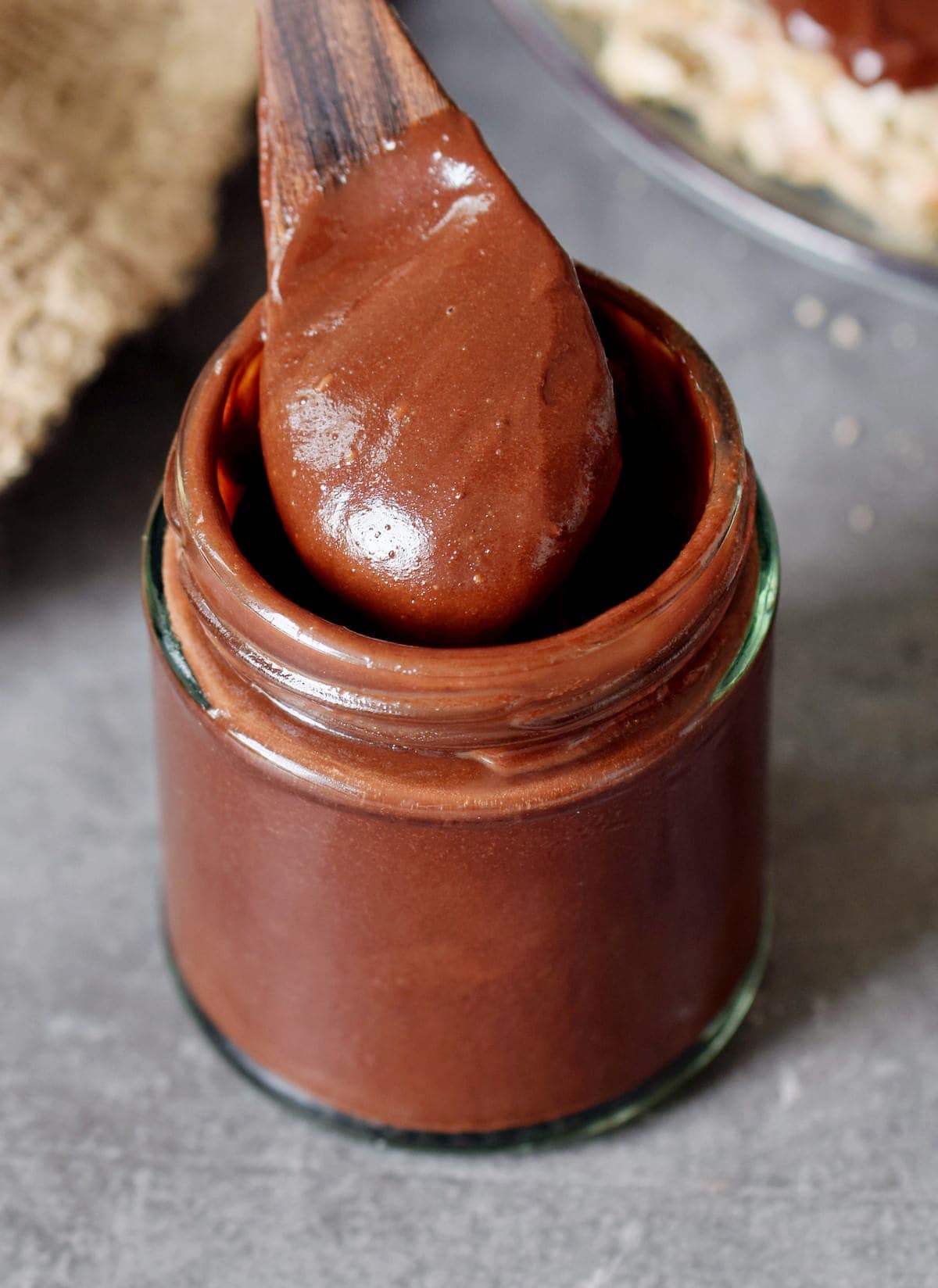hazelnut chocolate spread in a jar with wooden spoon