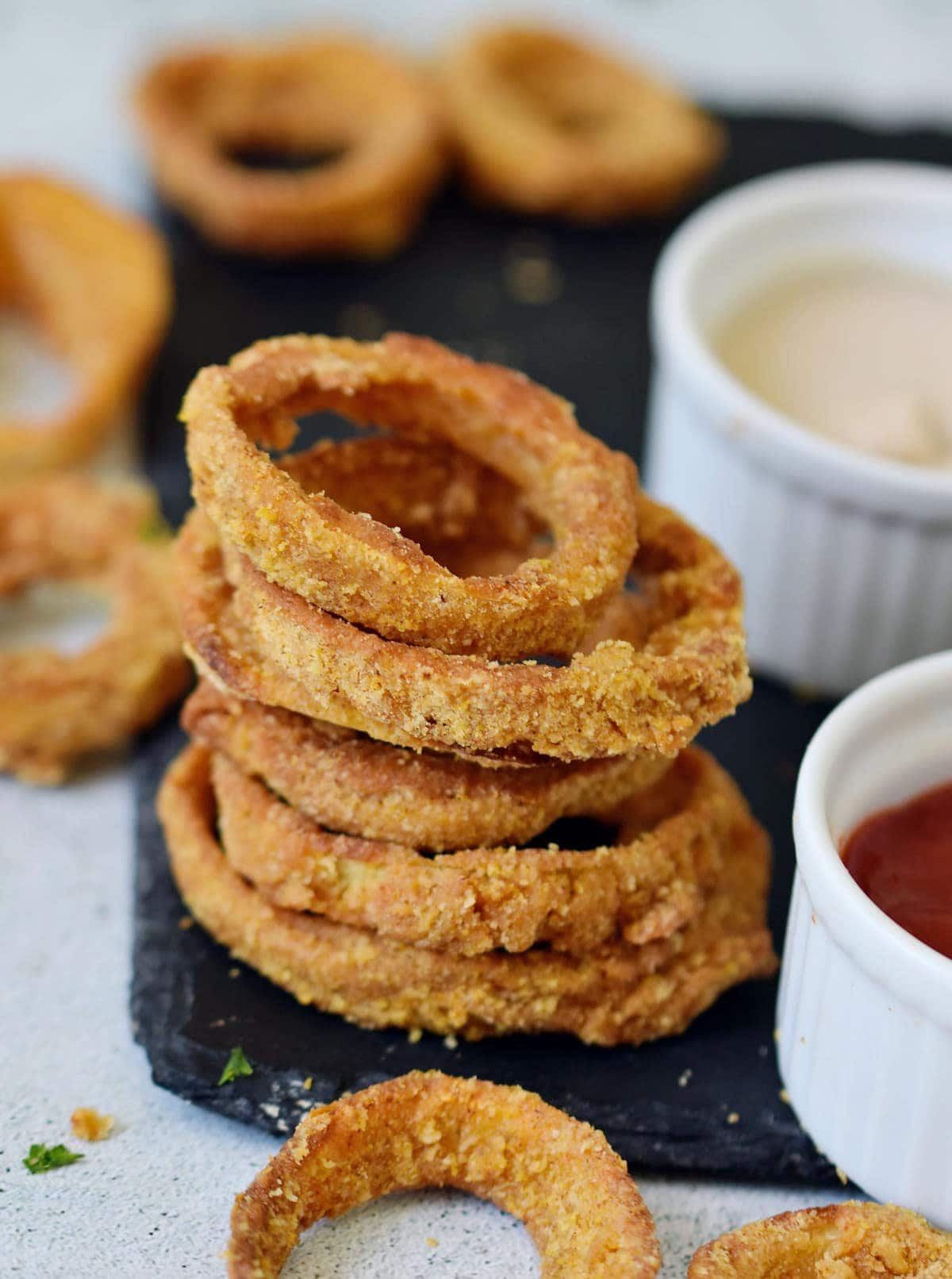 stack of baked gluten free onion rings with 2 dips
