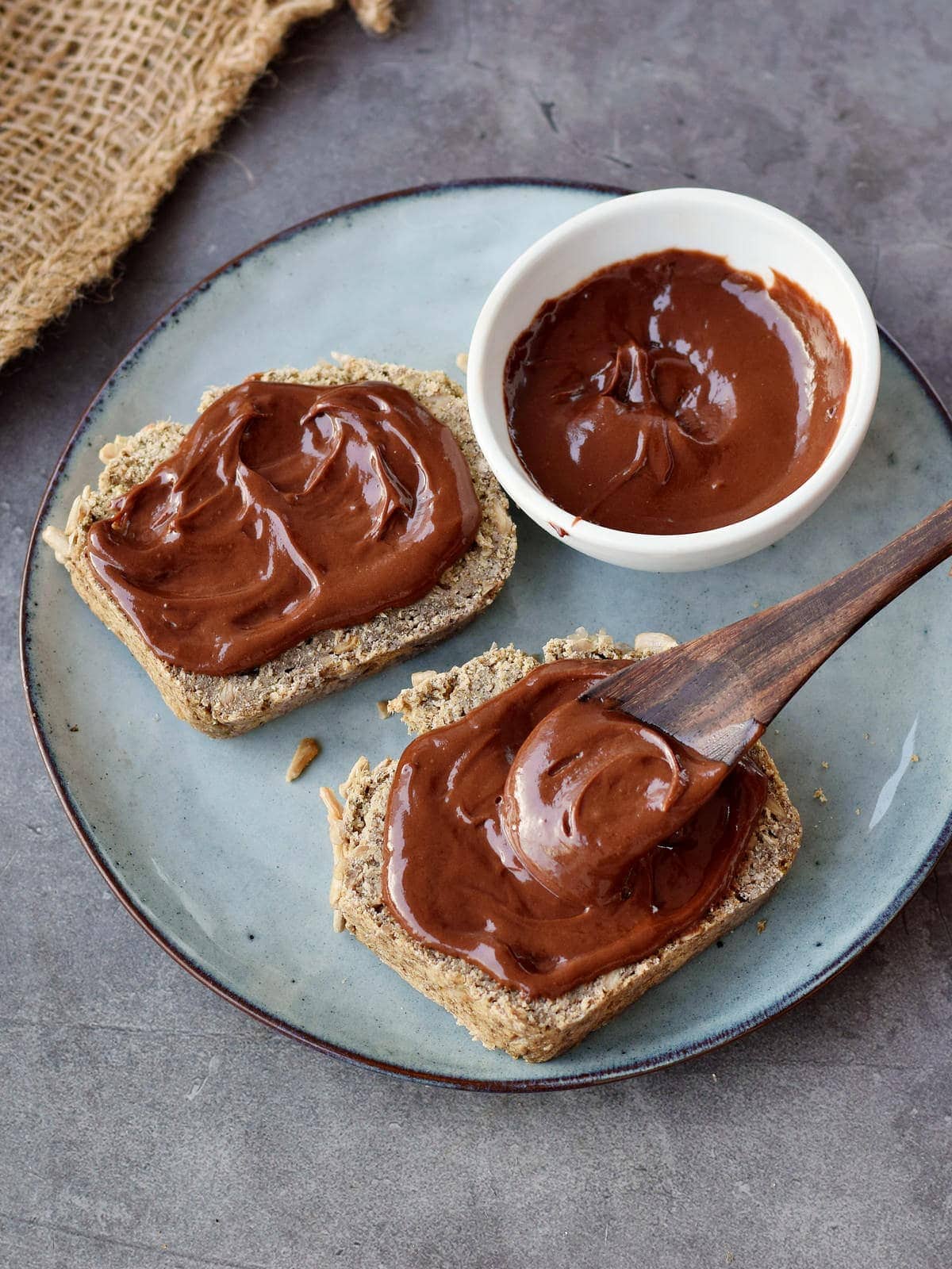 two slices of bread with homemade hazelnut chocolate spread on a plate