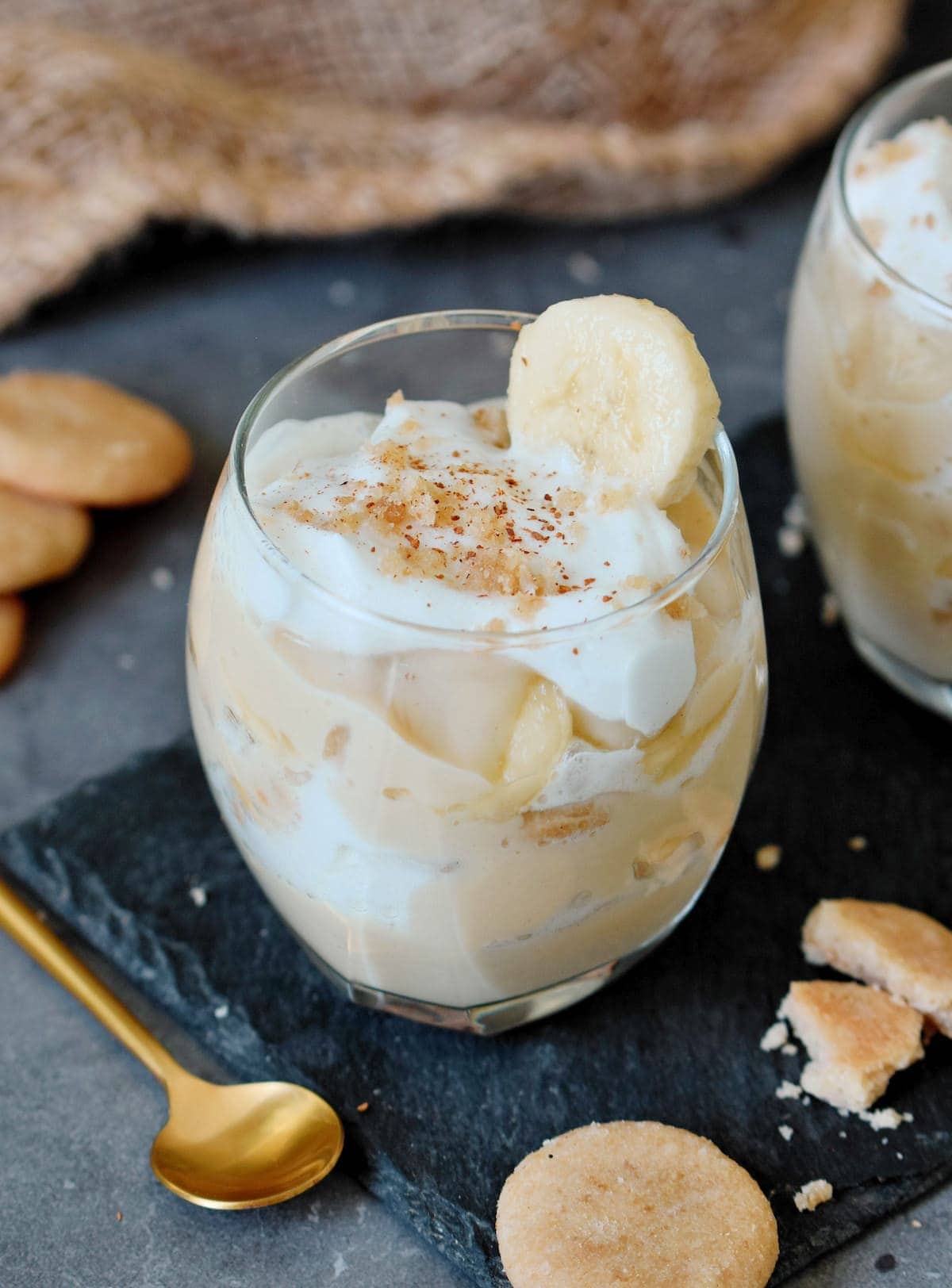 vegan pudding layered in jar with bananas whipped cream and vanilla wafers