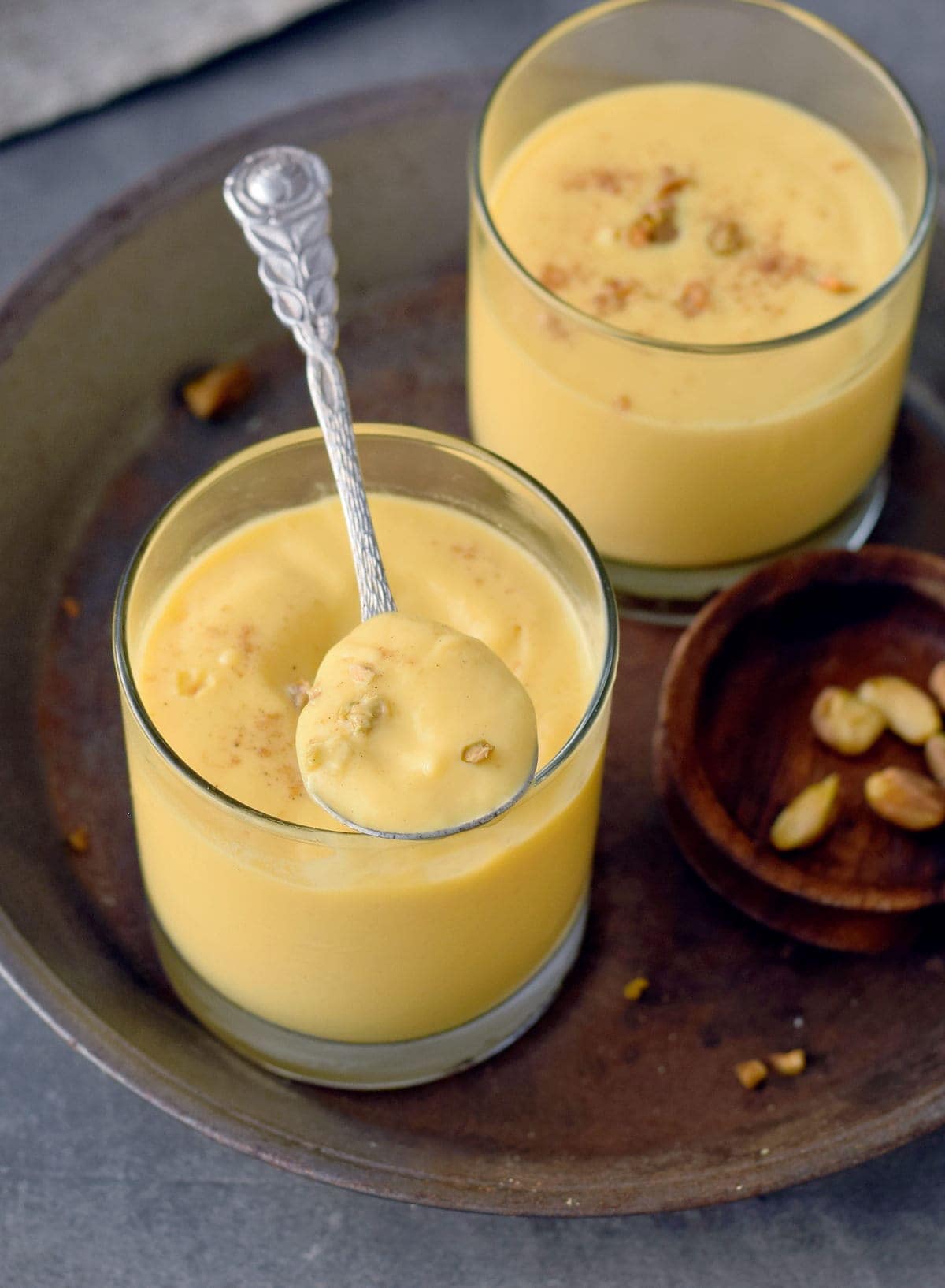 Indian mango lassi in jars with spoon