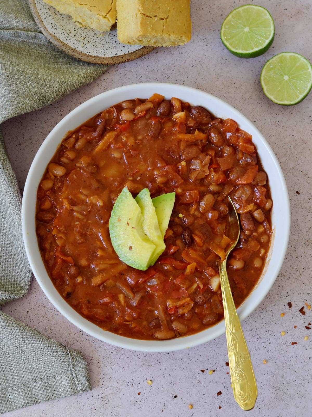 Vegan Chili in bowl with avocado slices and spoon