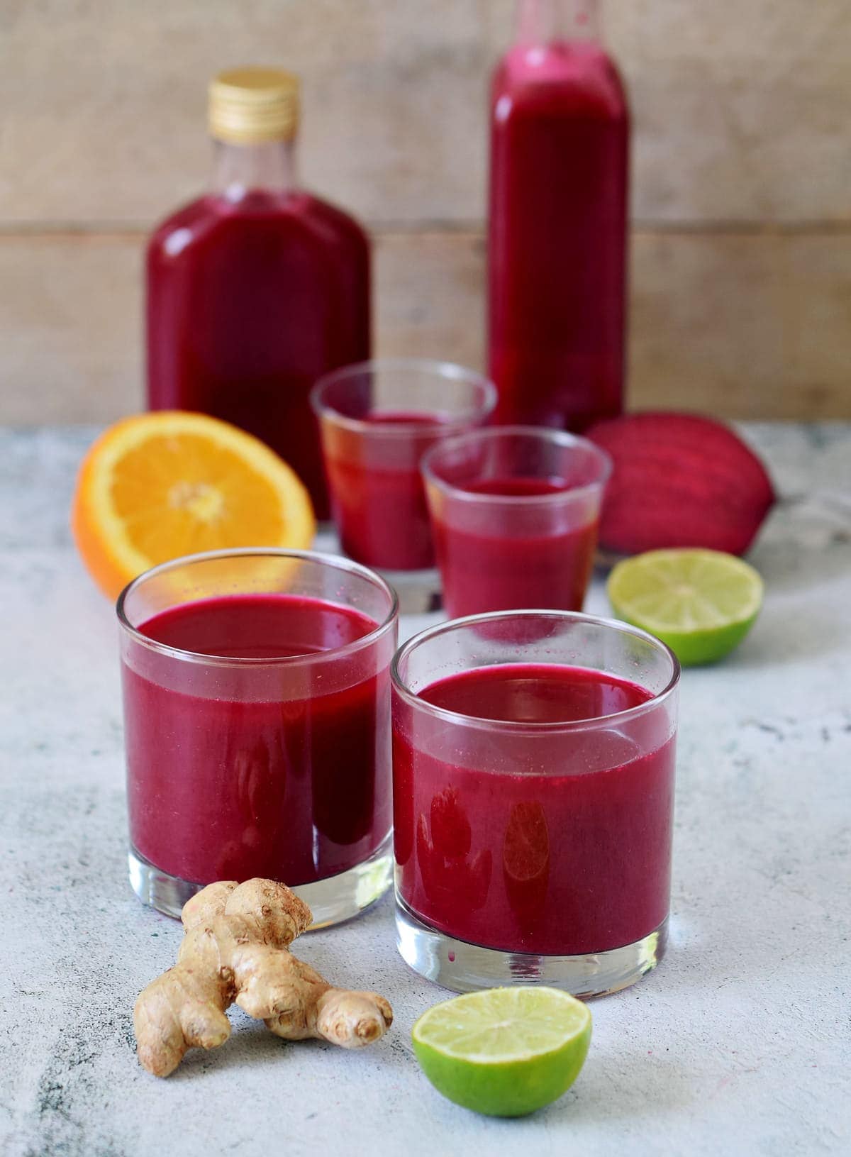 beetroot juice with orange, ginger in glasses and bottles
